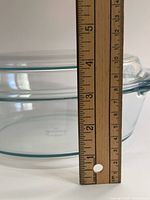 side view of casserole with lid, ruler indicating approximately 4 in. height