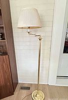 full view of polished brass floor lamp with shade