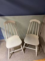 Front view of both white spindle-back chairs