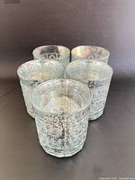 Five pressed glass candle holders front view