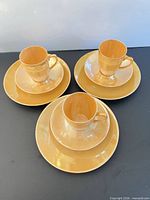 Complete set of three cups, three saucers, three dessert plates displayed