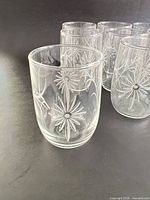 Close-up of one glass showing etched daisy pattern and clarity of glass