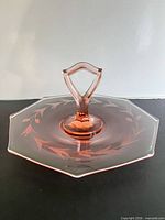 Oblique view showing pink glass tray, central handle, etched floral pattern