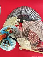 All seven fans opened to show front designs and materials