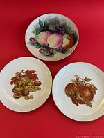 Front view of three fruit motif plates