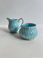 Creamer and sugar bowl side view displaying pearlescent glaze and gold trim