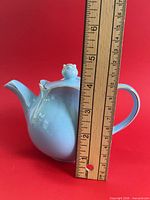 Side view of light blue Sadler teapot beside ruler showing height about 4.5 inches without lid finial