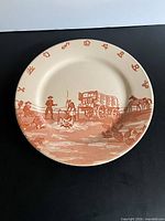 Front view of dinner plate showing full western scene and rim symbols