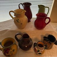 Seven of the ten pitchers displayed together on table