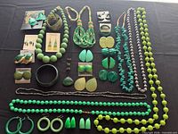All 28 green and turquoise jewelry pieces laid out