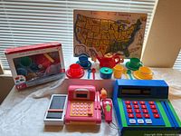 Entire lot showing boxed tea set, both cash registers, map puzzle, loose tea pieces