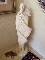 Sculpture of Native American man and small buffalo figurine