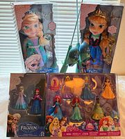 Front view of two boxed Frozen toddler dolls and combined mini figure packs
