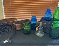 Group view of glass canisters and copper-tone planters