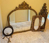 Four mirrors grouped: large landscape, tall narrow scroll, rectangular oval, round beaded