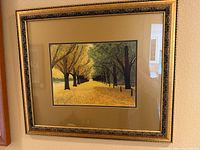 Full view of framed textile landscape artwork on wall