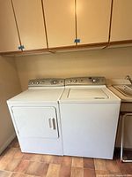 Front view of washer and dryer with closed doors and control panels