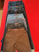 All eight pairs of jeans laid out to show colors and quantity