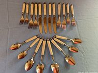 Flatlay of entire 24-piece flatware set: 6 knives, 8 forks, 10 spoons