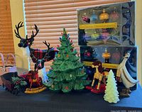 Group shot showing ceramic tree, two ornament boxes, small white tree, rocking horses, Santa duck, reindeer figures