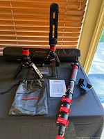 Mini pods, monopod, case, pouch, manual and mount displayed on table