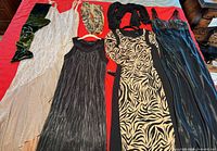 All dresses and scarves laid out on red surface