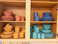 Entire cupboard view of four colour stoneware sets
