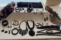 Overall lot showing scarves, necklaces, bracelets, earrings and ring laid out on table