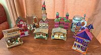 Group shot of all eight wooden music boxes, beer stein, glass mug and two miniature bottles