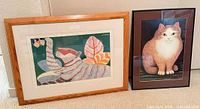 Both framed cat artworks side by side