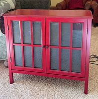 Front view showing red cabinet with twin glass doors and knob handles
