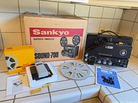Projector, box, reel, splicer, manual grouped on countertop