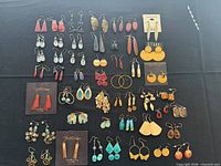 Full layout of all 49 pairs of earrings on black background