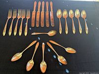 Flatware set laid out showing forks, knives, tablespoons and teaspoons