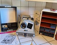 Projector, carry case interior, slide storage cabinet with slide boxes, instruction sheet