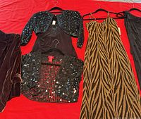 All four garments laid out: velvet blazer, sequin bolero, camisole, animal-print gown
