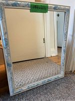 Front view of rectangular mirror showing white frame with blue accents