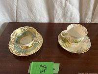 Both teacup and saucer sets side by side on table