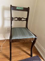 Full front view of wooden chair showing upholstery and carving