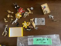 All jewelry items laid on table showing variety of brooches, earrings and boxes