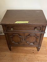 Front view of walnut veneer nightstand showing drawer, cabinet doors and feet