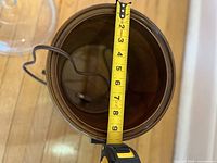 Interior showing brown ceramic insert and measuring tape depth; power cord visible