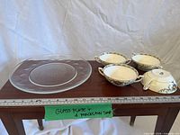 overall lot showing four handled soup bowls and glass charger on table with ruler