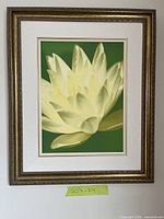 full view of framed floral photograph on wall with tape showing size