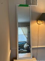 Front view of full-length white framed wall mirror