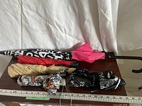 Group of five folded umbrellas on table