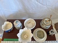 Overhead view of all seven ceramic pieces showing shapes and lids