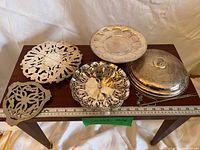 group shot showing all silver-plated pieces on table with ruler