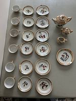 Full layout showing all 24 pieces including teapot, sugar bowl, creamer, cups, saucers, plates and tray