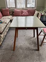 Top view of light green painted table with drop leaf extended, showing tapered wooden legs